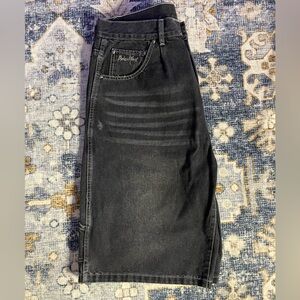 Black and white Broken Planet jorts with a skater vibe